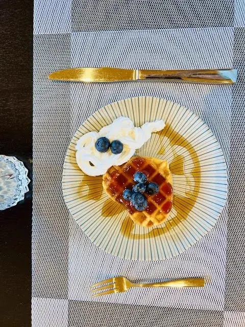 Waffle com chantilly, blueberries e geleia servido no café da manhã em Monte Verde MG