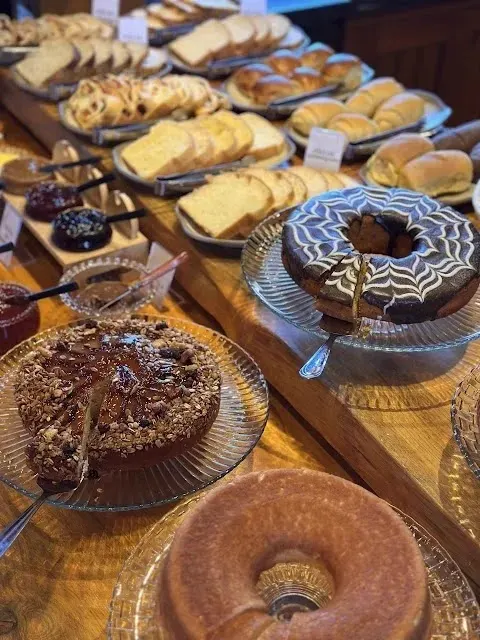 Mesa de bolos caseiros, pães e geleias do café da manhã colonial da Pousada Maple em Monte Verde MG